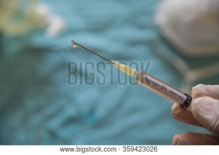 Close Up Shot Of A Syringe With The Word Coronavirus Vaccine.the Hand Holding It Is Pressing The Plu