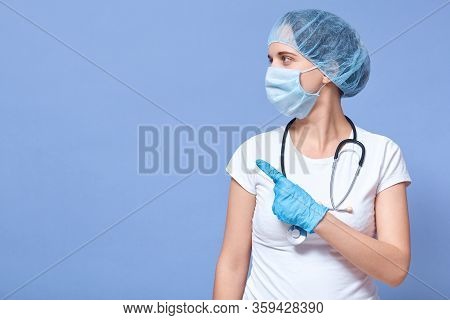 Picture Of Caucasian Doctor Woman Isolated Over Blue Studio Background, Wearing Hat, Gloves And Flum