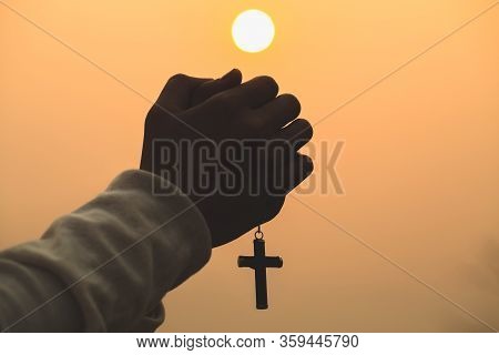 Both Hands Grasped The Cross To Pray To God. While The Sun Is Setting Or Rising Christian Religious 