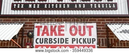 Babylon, New York, Usa - 1 April 2020: Take Out Only With Curbside Pickup Sign Posted On A Brick Wal