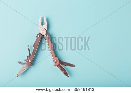 The Multitool Multi-function Tool Hovers On A Blue Background. The Concept Of An Expanded Multi-tool