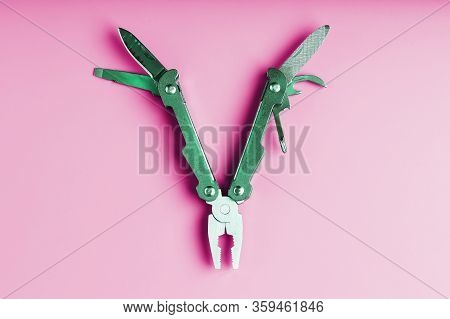 Multitool Is A Multi-functional Tool On A Pink Background. The Concept Of An Open, Flying Multi-tool