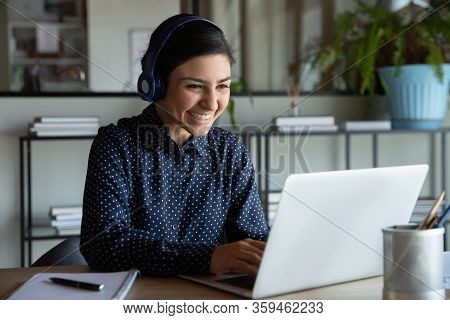 Happy Young Indian Ethnicity Female Manager In Headphones Working Remotely.