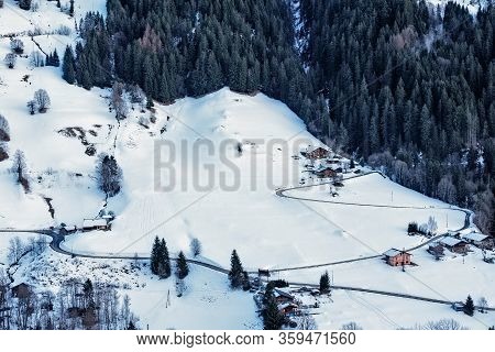 Road Going Through A Village Full Of Snow In The French Alps