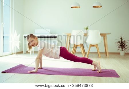 Pretty Happy Child Girl Having Fun Making Yoga Exercises At Home During Coronavirus Quarantine