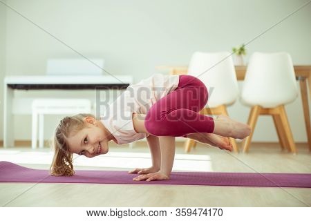Pretty Happy Child Girl Having Fun Making Yoga Exercises At Home During Coronavirus Quarantine