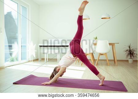Pretty Happy Child Girl Having Fun Making Yoga Exercises At Home During Coronavirus Quarantine