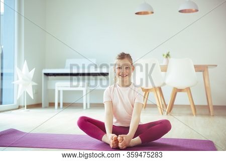 Pretty Happy Child Girl Having Fun Making Yoga Exercises At Home During Coronavirus Quarantine