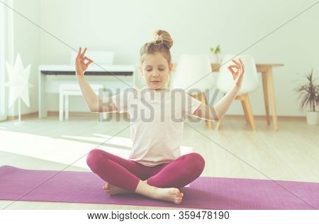 Pretty Happy Child Girl Having Fun Making Yoga Exercises At Home During Coronavirus Quarantine