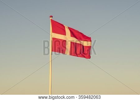 Danish Flag At Dawn Waving In The Wind In The Sunset On A Sunny Evening