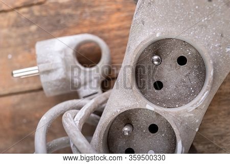 Old Dirty Extender On A Wooden Table. Electrical Accessories In The Workshop.