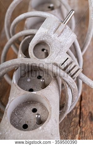Old Dirty Extender On A Wooden Table. Electrical Accessories In The Workshop.