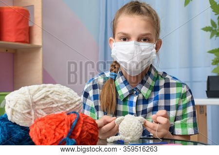 A Girl In Quarantine Self-isolation Is Engaged In Knitting