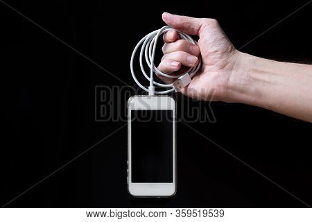 Man Holding Smartphone With Empty Screen Isolated On Black Background. Male Hands With Phone, Space 