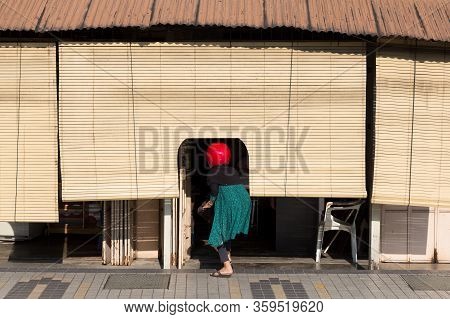 A Woman With A Case Enters A Penang Store, Georgewtown, Malaysia