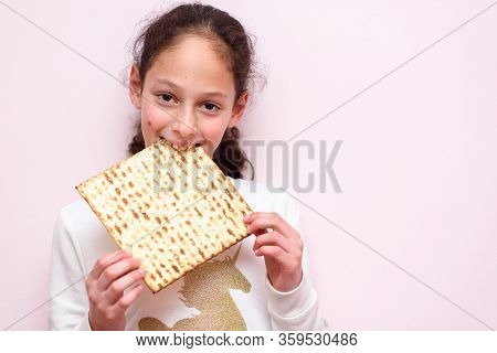Portrait Of The Cute Teenager Girl Holding Matzah. Jewish Child Eating Matzo Unleavened Bread In Jew