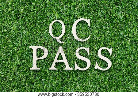 Wood Alphabet Letter In Word Qc (abbreviation Of Quality Control) Pass On Green Grass Background