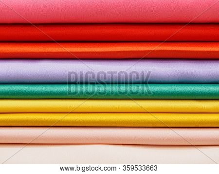Samples Of Colored Satin Fabrics Close-up. Large Assortment Of Bright Fabrics In The Store. A Tailor