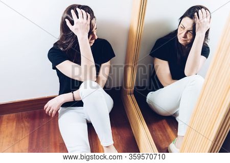 A Abused Young Woman With Her Hand On Her Head, Crying With Bruises Under Her Eyes