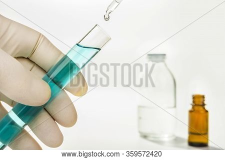 Dripping Reagent Into Test Tube With Liquid Sample