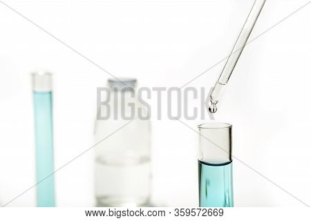 Dripping Reagent Into Test Tube With Liquid Sample
