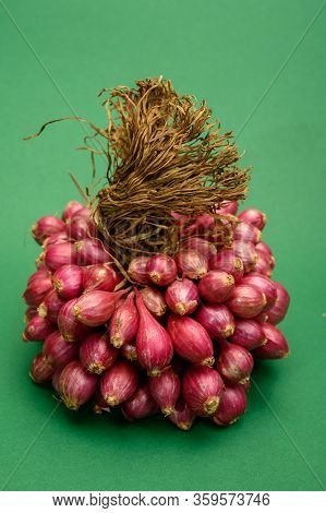 Bunch Of High Quality Small Red Shallot Sambar Onions From India On Green Background