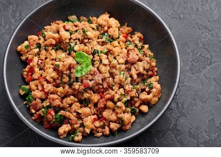 Pad Krapow Gai - Thai Basil Chicken In Black Bowl At Dark Slate Background. Pad Krapow Is Thai Cuisi