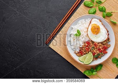 Pad Krapow Gai - Thai Basil Chicken With Rice And Fried Egg Black Slate Background. Pad Krapow Is Th