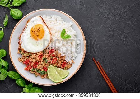 Pad Krapow Gai - Thai Basil Chicken With Rice And Fried Egg Black Slate Background. Pad Krapow Is Th