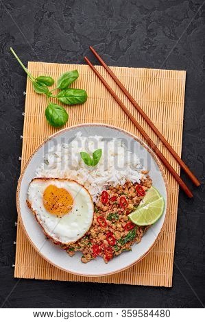 Pad Krapow Gai - Thai Basil Chicken With Rice And Fried Egg Black Slate Background. Pad Krapow Is Th