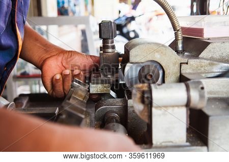 Locksmith In Workshop Makes New Key. Professional Making Key In Locksmith. Machine Production Of Dup