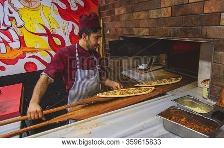 Istanbul, Turkey: Chef Of Bakery Making A Turkish Pizza Or Pide. Dough, Minced Meat, Cheese And Vege