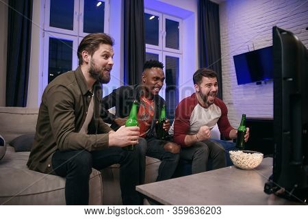 Likable Joyful Multiracial Young Guys Cheering Their Favourite Football Team With Screams And Hands 