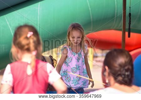 Young Mother With Her Daughter In Hot Weather, Cool Off At The Gates Of Climate Control In The Water