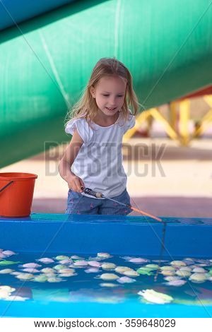 Young Mother With Her Daughter In Hot Weather, Cool Off At The Gates Of Climate Control In The Water