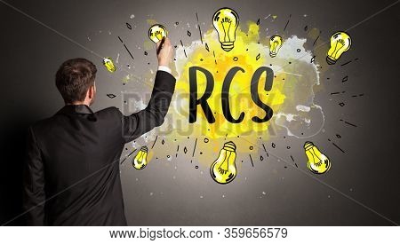 businessman drawing colorful light bulb with RCS abbreviation, new technology idea concept