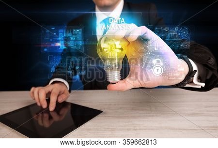 Businessman holding lightbulb with DATA ANALYSIS inscription, online security idea concept