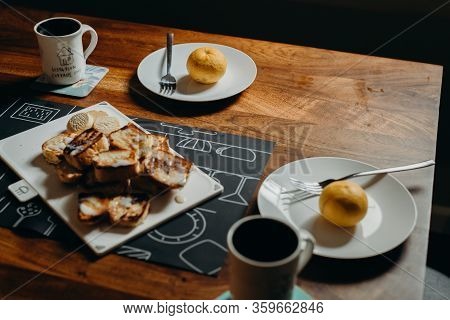 Table Setting For Breakfast - Plate, Fork, Cup And Toast On The Wooden Table.