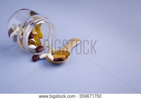 Food Supplements In Glass Bottle On Blue Background