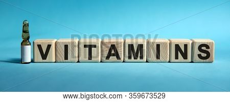 Vitamins - Text On Cubes. Drug In Ambula To Reduce Disease Symptoms On A Blue Background