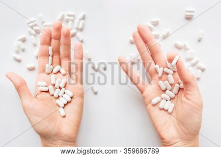 Palm Hands Full Of White Scattering Pills. Capsules With Medicines On Light Background. Flat Lay, To