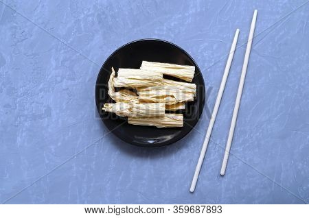 Soy Tofu Yuba Leather With Spices In The Center Of The Frame On A Brown Plate On A Gray Neutral Back