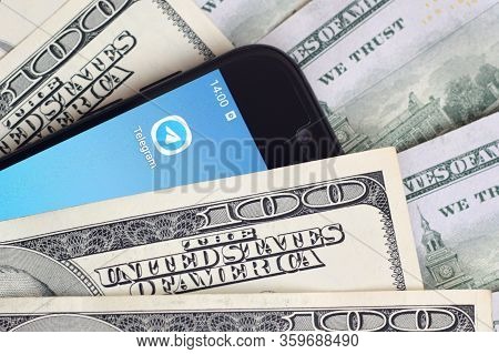 Smartphone Screen With Telegram App And Lot Of Hundred Dollar Bills. Business And Social Networking 