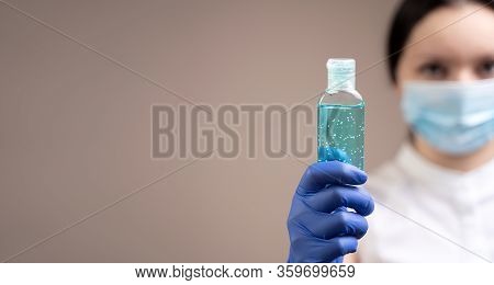 A Girl In A Medical Mask And Rubber Gloves Is Holding An Alcohol Gel, A Concept To Prevent The Sprea