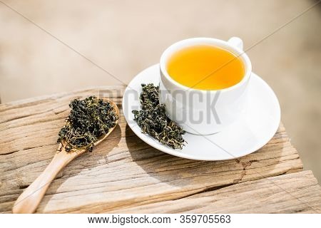 Dry Gynostemma Pentaphyllum Leaf With Brewed Tea In A White Cup On The Wood Floor