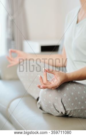 Young Woman Keeping Hands In Shuni Mudra When Meditating On Sofa At Home