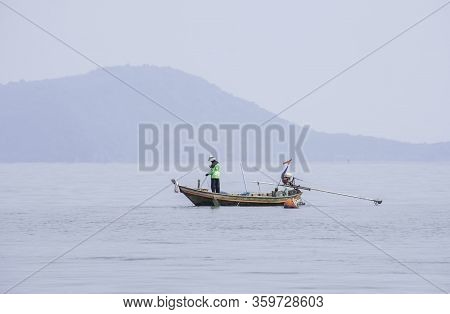 Fishermen Netting Fish On A Boat At Sea At Koh Talu , Prachuap Khiri Khan In Thailand.