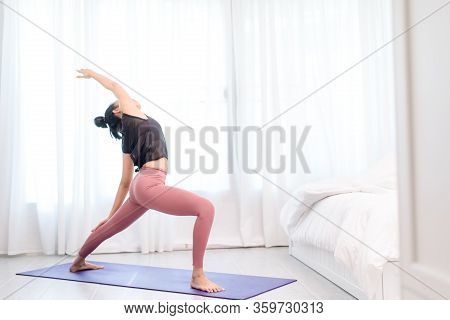 Young Woman Do Yoga In A Bed Room