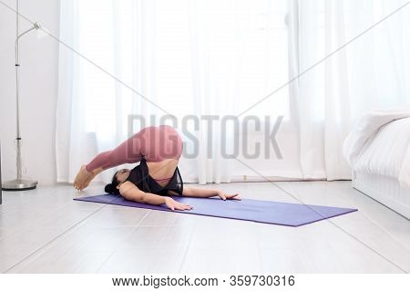 Young Woman Do Yoga In A Bed Room