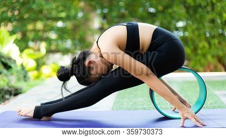 Asian Woman Practice Yoga In A Garden